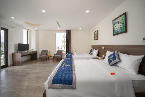 a hotel room with a large bed and a living room at Nam Thu Hotel in Quy Nhon