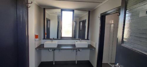 a bathroom with two sinks and two mirrors at The Federal Hotel in Kalgoorlie