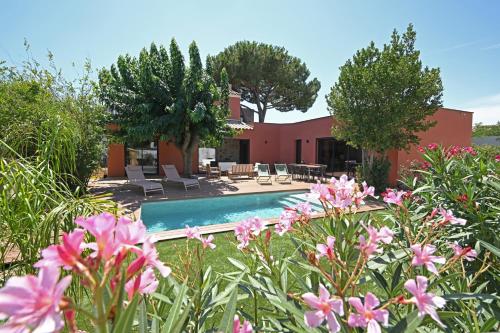 une villa avec une piscine et des fleurs dans l'établissement Maison B, au Grau-dʼAgde
