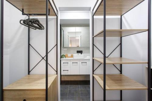 Habitación con estanterías y baño con lavabo. en Luxe 3BR Villa with Kitchen & Laundry, en Perth