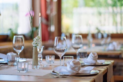 a table with wine glasses and napkins on it at Naturhotel Miraval in Perca