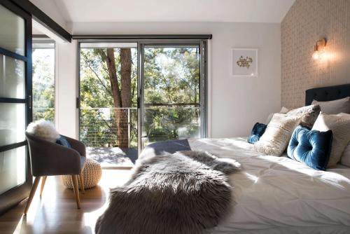 ein Schlafzimmer mit einem großen Bett mit einem großen Fenster in der Unterkunft Daruma Hepburn - Daylesford Region in Hepburn Springs