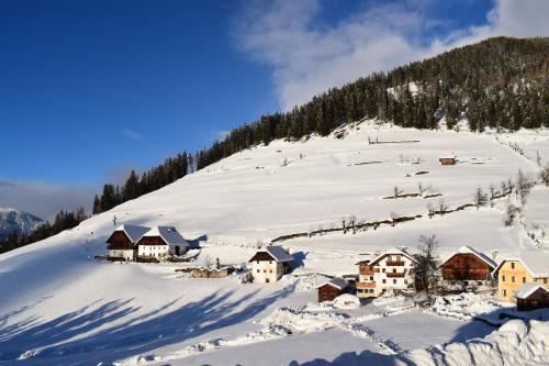 a snow covered mountain with houses on a slope at Naturhotel Miraval in Perca