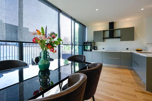 een keuken en eetkamer met een glazen tafel en stoelen bij 12B, Luxe Designer Oase ~ Historisch Centrum ~ Uitzicht in Oisterwijk
