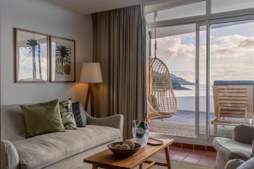 - un salon avec un canapé et une vue sur l'océan dans l'établissement Langley Resort Fort Royal, à Deshaies