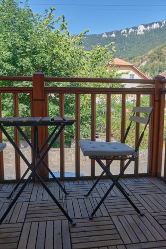 a chair and a table on a wooden deck at À l'étape rêvée, charme, calme et nature in Baulmes