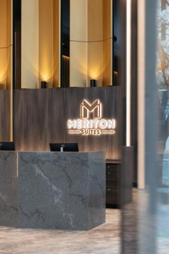 a reception desk in a building with a sign on it at Meriton Suites Canberra in Canberra