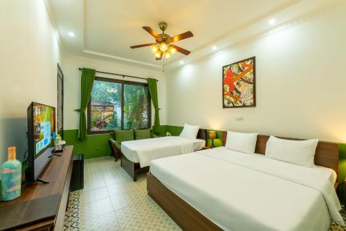 a hotel room with two beds and a flat screen tv at Tam Coc Moment Homestay in Ninh Binh