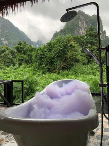 a bath tub with a view of a mountain at Bridge Hill Cafe Glamping in Khao Sok