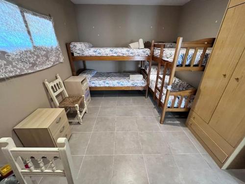 um quarto com 2 beliches e piso em azulejo em Finca Aideta- casa confortable con barbacoa 