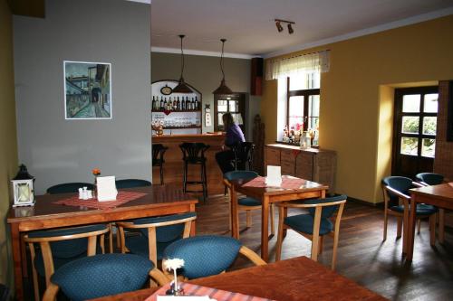 ein Restaurant mit Tischen und Stühlen und eine Frau im Hintergrund in der Unterkunft Reitmayer in Nový Smokovec