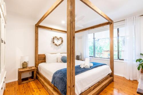 a bedroom with a bed and a window at Woodlands Seaside - Coastal Calm in Avoca Beach in Avoca Beach