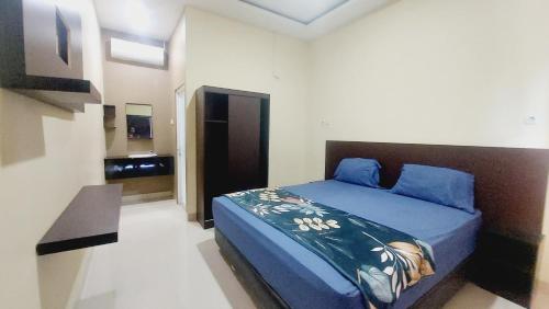 Schlafzimmer mit einem Bett mit blauer Decke in der Unterkunft SASANDO RESIDENCE KUPANG in Maulafa