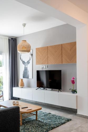 a living room with a large television and a table at Kition City Apartments - Central Location in Larnaca