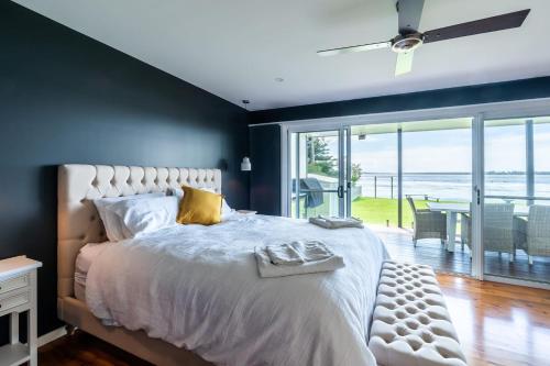 a bedroom with a large bed with a view of the ocean at On The Corso - Sun-soaked Serenity with Lake Access in Gorokan