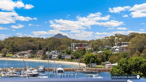 a group of boats are docked at a beach at Belvedere Bayfront in Nelson Bay