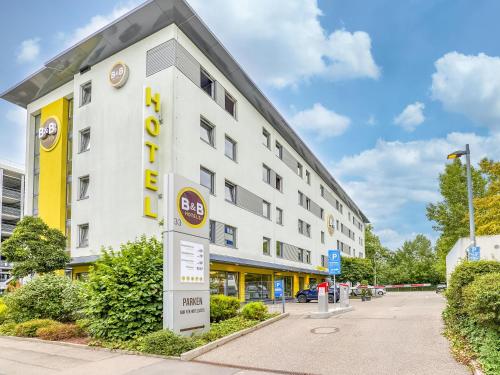 ein Hotelgebäude mit einem Schild davor in der Unterkunft B&B Hotel Stuttgart-Vaihingen in Stuttgart