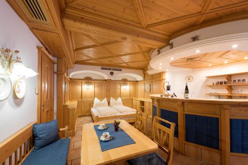 ヴァークラインにあるLandhaus Hubertusの木製の壁の客室で、テーブルとソファが備わります。