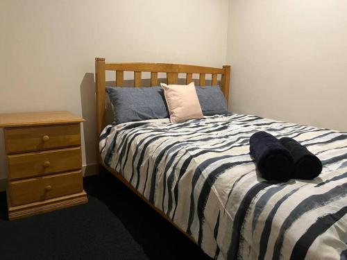 a bedroom with a bed with a black and white comforter at Spacious, Central 2 QB Melbourne CBD Apt near Flinders Stn, Town Hall in Melbourne