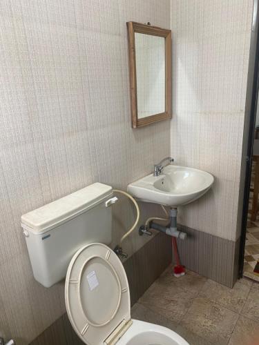 a bathroom with a toilet and a sink at Baga Beach Prime in Baga