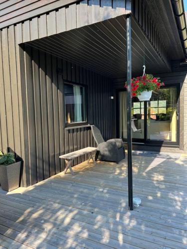 a wooden deck with a bench and a potted plant at Rigmorhuset in Fjordgård