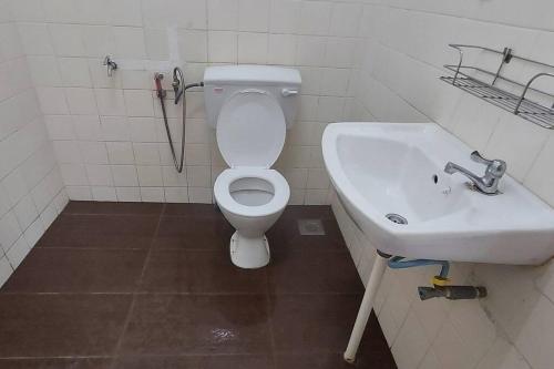 a bathroom with a white toilet and a sink at SDA Homestay Pool @StadiumDarulAman Untuk Muslim Sahaja in Alor Setar