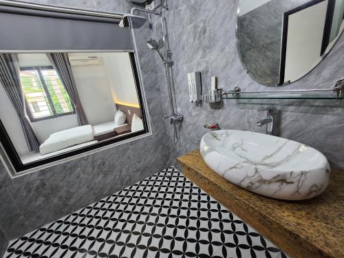 ein Bad mit einem Waschbecken und einem Spiegel in der Unterkunft KL Retreat Hotel in Thanh Hóa