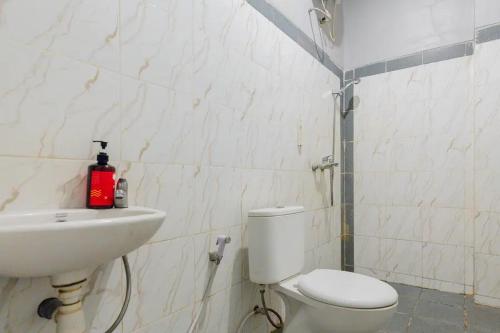 een badkamer met een toilet en een wastafel bij RedDoorz @ Manukan Surabaya in Surabaya