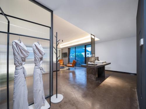 ein Zimmer mit zwei Kleiderstangen aus weißen Bademänteln in der Unterkunft Tingting Lingshanjiang Light Luxury Art Homestay in Longyou