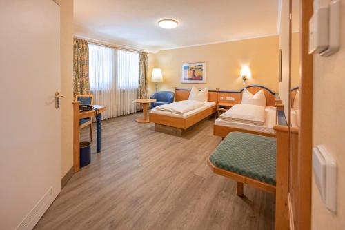ザウアーラッハにあるHotel Neuwirtのベッド2台とデスクが備わるホテルルームです。