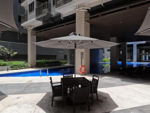 una mesa y sillas con sombrilla en un patio en 1 Bedroom in Pasay Mall of Asia- HAVEN GRACE, en Manila