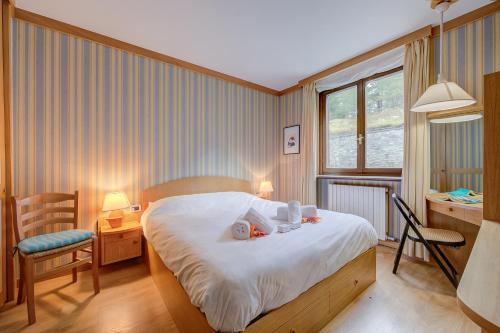 a bedroom with a bed and a desk and a chair at Appartamento Alpetta 37 Ski In - Ski Out - Happy Rentals in Sestriere