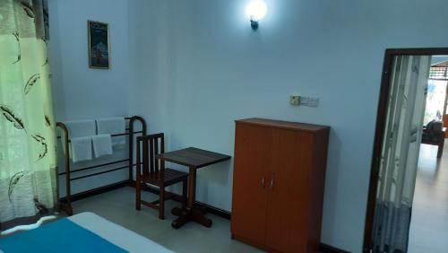 a bedroom with a bed and a table and a chair at CASA VACANSA HOME STAY in Hungama