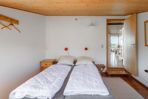 een slaapkamer met een groot bed met witte lakens bij Magnificent house with splendid view to the sea in Fåborg