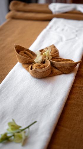 a napkin with a brown napkin with flowers on it at Estrella Boutique Hotel in Da Nang