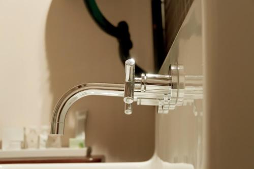 a bathroom sink with a water faucet at Suitehotel Pincoffs in Rotterdam