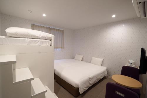 a small room with a bed and a table at CVS Bay Hotel New Building in Urayasu