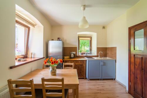 kuchnia z drewnianym stołem i lodówką w obiekcie Apartament Wielka Sowa w mieście Głuszyca Górna