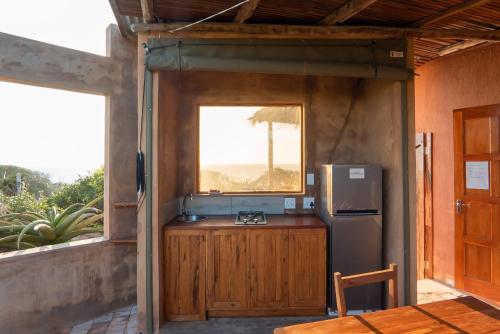 uma cozinha com um frigorífico e uma janela em Bela Flor Beach Front Apartments em Inhambane