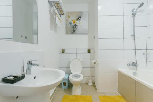 a white bathroom with a sink and a toilet at Adrich Properties East Legon in East Legon