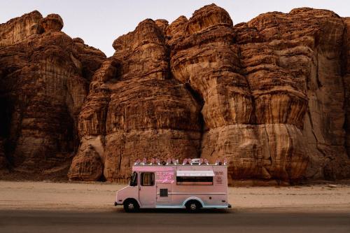 um camião de gelados estacionado em frente a uma montanha em Caravan by Habitas AlUla em Al-ʿUla