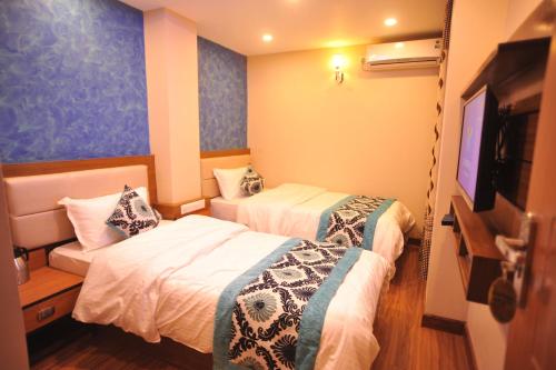Habitación de hotel con 2 camas y TV de pantalla plana. en Hotel Arati Pvt. Ltd. en Katmandú