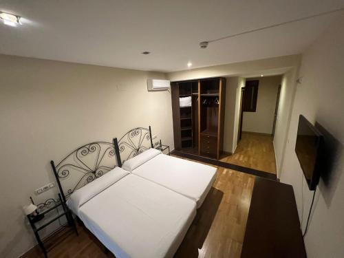 1 dormitorio con 1 cama blanca en una habitación en Hostal el Pasaje, en Puente Genil