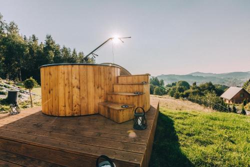 a wooden deck with a hot tub and stairs at Domki Bliżej Chmur in Duszniki Zdrój