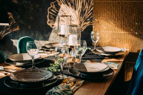 a table with plates and wine glasses on it at Domki Bliżej Chmur in Duszniki Zdrój