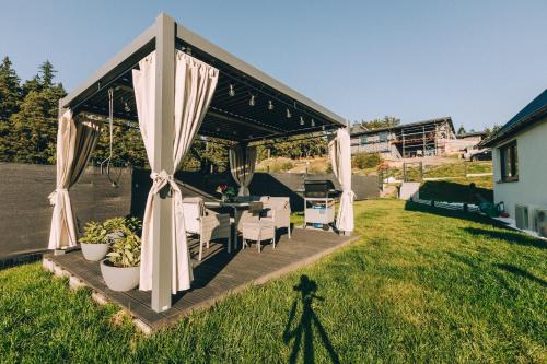 a gazebo with a table and chairs in a yard at Domki Bliżej Chmur in Duszniki Zdrój