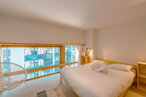 une chambre avec un lit et une grande fenêtre dans l'établissement Résidence Grand Roc - Campanules 322 - Happy Rentals, à Chamonix-Mont-Blanc