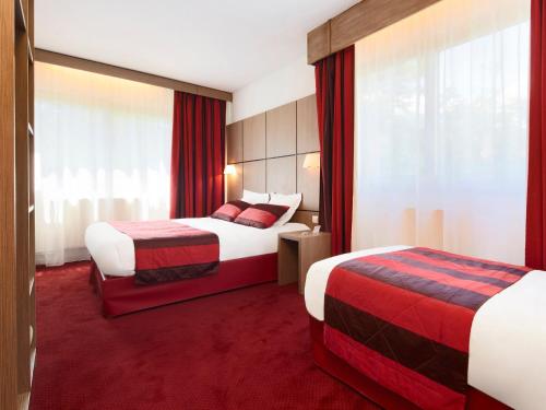 2 camas en una habitación de hotel con alfombra roja en Kyriad Grenoble Centre en Grenoble