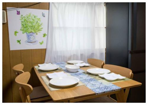 a wooden table with white plates and bowls on it at I Love Matsuyama in Matsuyama
