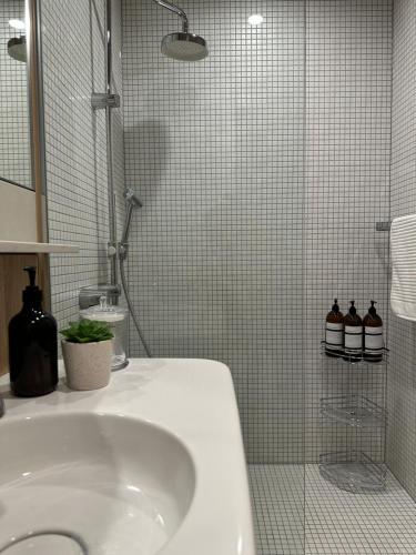 a white bathroom with a sink and a shower at Palko - Oasis in the City in Canberra
